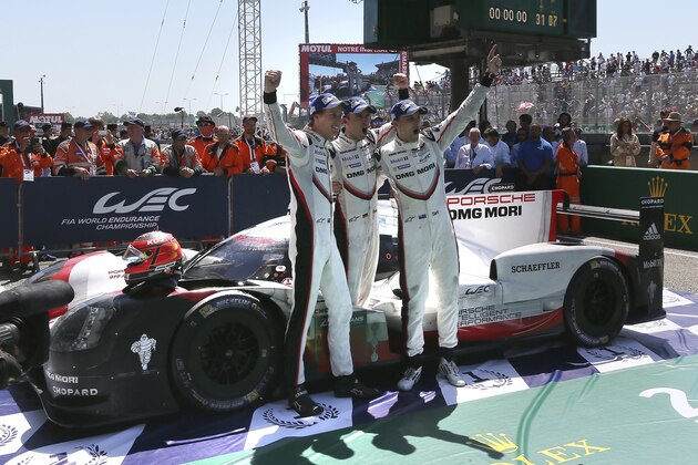 Drivers of the Porsche 919 Hybrid No2, from left to right, Brendon Hartley of New Zealand, Earl Bamber of New Zealand and Timo Bernhard of Germany celebrate after winning the 85th 24-hour Le Mans endurance race, in Le Mans, western France, Sunday, June 18, 2017. (AP Photo/David Vincent)