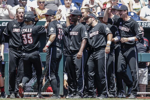 Louisville's Colin Lyman (35) is greeted at the dugout after scoring against Texas A&M on a two-run single by Colby Fitch in the third inning of an NCAA College World Series baseball game in Omaha, Neb., Sunday, June 18, 2017. Louisville won 8-4. (AP Photo/Nati Harnik)