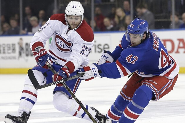 Montreal Canadiens' Alex Galchenyuk, left, and New York Rangers' Brendan Smith compete for the puck during the third period in Game 3 of an NHL hockey first-round playoff series, Sunday, April 16, 2017, in New York. The Canadiens defeated the Rangers 3-1. (AP Photo/Seth Wenig)