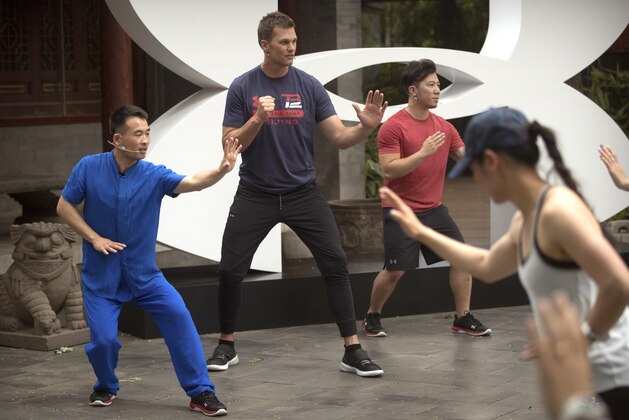 New England Patriots quarterback Tom Brady, center, practices a martial-arts technique during a promotional event in Beijing, Sunday, June 18, 2017. The Super Bowl-winning quarterback is on a weeklong promotional tour of China and Japan for a sportswear maker that kicked off on Sunday with a stop in China's capital. (AP Photo/Mark Schiefelbein)