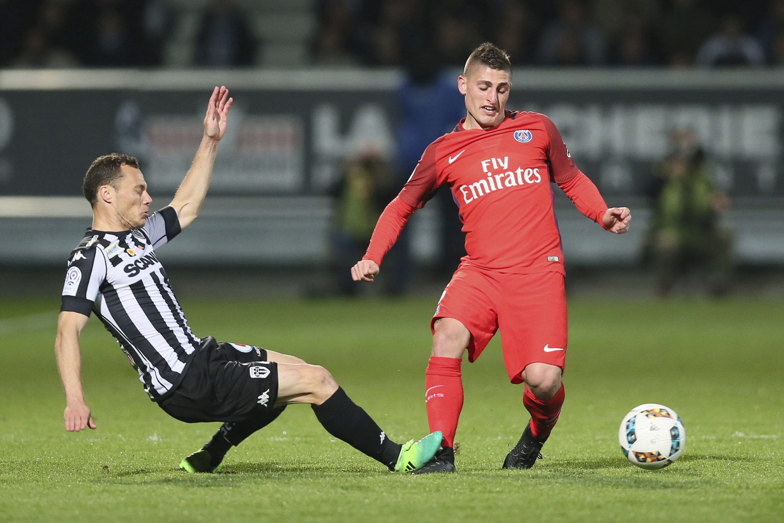 Paris Saint Germain's midfielder Marco Verratti of Italy, right, is tackled by Angers' defender Vincent Manceau during their French League One soccer match, in Angers, western France, Friday, April 14, 2017. Paris won 2-0. (AP Photo/David Vincent)