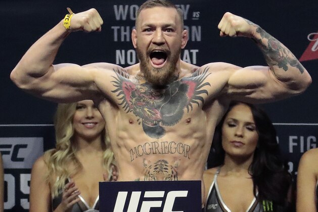 FILE - In this Nov. 11, 2016, file photo, Conor McGregor stands on a scale during the weigh-in event for his fight against Eddie Alvarez in UFC 205 mixed martial arts at Madison Square Garden in New York.  Floyd Mayweather Jr. says facing UFC star McGregor in a boxing ring
