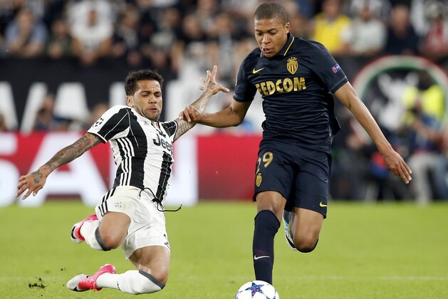 Juventus' Dani Alves, left, and Monaco's Kylian Mbappe, right, challenge for the ball during the Champions League semi final second leg soccer match between Juventus and Monaco in Turin, Italy, Tuesday, May 9, 2017. (AP Photo/Antonio Calanni)