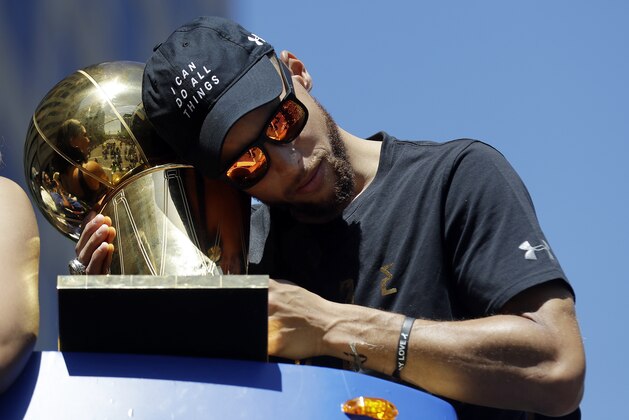Golden State Warriors' Stephen Curry holds the Larry O'Brien trophy during a parade and rally in honor of the Warriors, Thursday, June 15, 2017, in Oakland, Calif., to celebrate the team's NBA basketball championship. (AP Photo/Marcio Jose Sanchez)