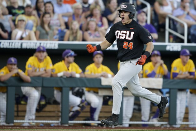 CORRECTS OREGON STATE PLAYERS IN BACKGROUND TO LSU - Oregon State's KJ Harrison (24) celebrates his grand slam while rounding the bases as LSU players watch from the dugout in the sixth inning of an NCAA College World Series baseball game in Omaha, Neb., Monday, June 19, 2017. (AP Photo/Nati Harnik)