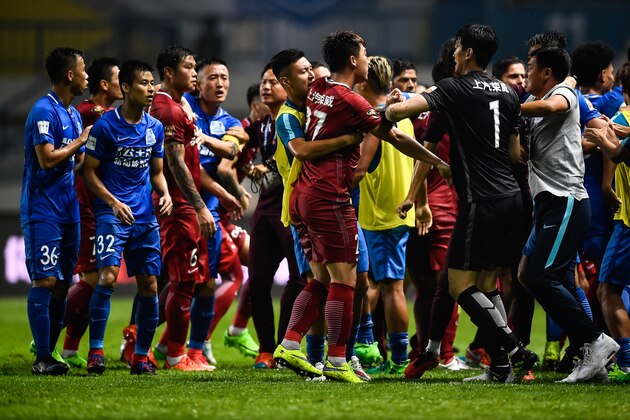 This photo taken on June 18, 2017 shows a brawl between Shanghai SIPG players (in red) and Guangzhou R&F players (in blue), during their Chinese Super League football match in Guangzhou, in China's southern Guangdong province. 
Brazilian international Oscar triggered a mass brawl in the Chinese Super League as players and staff from his Shanghai SIPG side and opponents Guangzhou R&F scrapped on the pitch. / AFP PHOTO / STR / China OUT        (Photo credit should read STR/AFP/Getty Images)