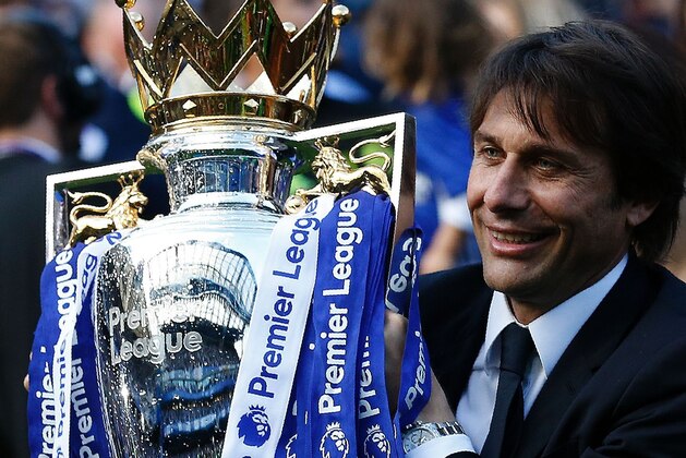 Chelsea's Italian head coach Antonio Conte holds the English Premier League trophy, as players celebrate their league title win at the end of the Premier League football match between Chelsea and Sunderland at Stamford Bridge in London on May 21, 2017.
Chelsea's extended victory parade reached a climax with the trophy presentation on May 21, 2017 after being crowned Premier League champions with two games to go.  / AFP PHOTO / Ian KINGTON / RESTRICTED TO EDITORIAL USE. No use with unauthorized audio, video, data, fixture lists, club/league logos or 'live' services. Online in-match use limited to 75 images, no video emulation. No use in betting, games or single club/league/player publications.  /         (Photo credit should read IAN KINGTON/AFP/Getty Images)