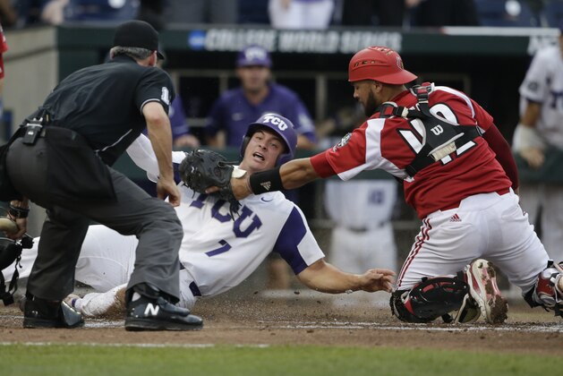 TCU's Josh Watson (7) is safe at home before the tag by Louisville catcher Colby Fitch during the second inning of an NCAA College World Series baseball game in Omaha, Neb., Thursday, June 22, 2017. (AP Photo/Nati Harnik)