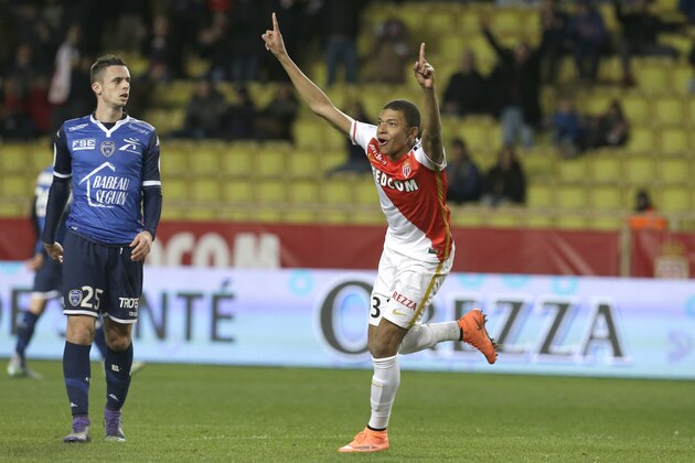 Monaco's Kylian Mbappe Lottin reacts in front Troyes's Jessy Pi after scoring the third goal against Troyes during their French League One soccer match, Saturday, Feb. 20, 2016, in Monaco. (AP Photo/Lionel Cironneau)
