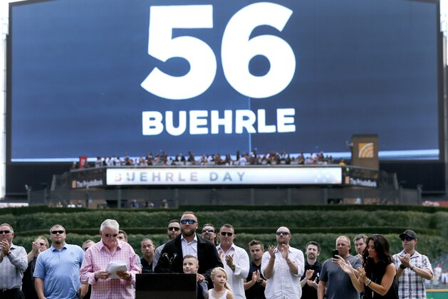 Former Chicago White Sox pitcher Mark Buehrle, center, watches with family and teammates as his No. 56 is retired and displayed on a video board by the team during ceremonies before a baseball game between the White Sox and the Oakland Athletics Saturday, June 24, 2017, in Chicago. (AP Photo/Charles Rex Arbogast)