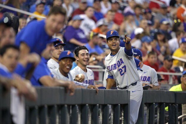 Florida's Nelson Maldonado (27) and the Florida dugout reacts after watching replay of a score by Christian Hicks in the seventh inning of an NCAA College World Series baseball elimination game against TCU in Omaha, Neb., Saturday, June 24, 2017. (AP Photo/Nati Harnik)