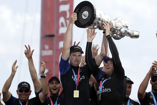 Emirates Team New Zealand helmsman Peter Burling, left, and teammate Glenn Ashby hold the Americas Cup aloft as they celebrate with teammates after defeating Oracle Team USA in the America's Cup sailing competition Monday, June 26, 2017, in Hamilton, Bermuda. (AP Photo/Gregory Bull)