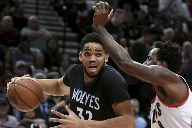 Minnesota Timberwolves center Karl-Anthony Towns drives to the basket on Portland Trail Blazers forward Al-Farouq Aminu during the first half of an NBA basketball game in Portland, Ore., Thursday, April 6, 2017. (AP Photo/Steve Dykes)