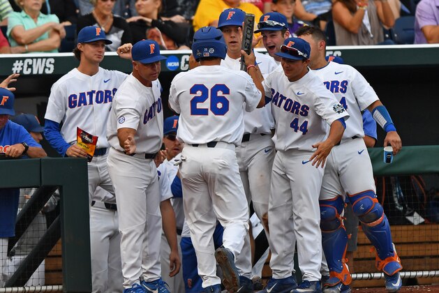 OMAHA, NE - JUNE 27:  Center fielder Nick Horvath #26 of the Florida Gators celebrates with his teammates after scoring a run against the LSU Tigers in the second inning during game two of the College World Series Championship Series on June 27, 2017 at TD Ameritrade Park in Omaha, Nebraska.  (Photo by Peter Aiken/Getty Images)