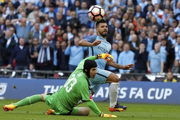 Manchester City's Sergio Aguero, left, scores the opening goal past Arsenal goalkeeper Petr Cech during the English FA Cup semifinal soccer match between Arsenal and Manchester City at Wembley stadium in London, Sunday, April 23, 2017. (AP Photo/Kirsty Wigglesworth)
