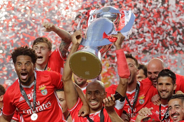 Benfica's Brazilian defender Luisao (C) holds the Portuguese League trophy past teammates as they celebrate winning their 36th title at the end of the Portuguese league football match SL Benfica vs Vitoria Guimaraes SC at the Luz stadium in Lisbon on May 13, 2017.
Lisbon giants Benfica clinched a fourth straight Portuguese league title on May 13, 2017 with a 5-0 victory over Vitoria Guimaraes.
The champions have an unassailable 81 points from 33 games and cannot be caught by Porto, who are eight points behind with just two games to play. / AFP PHOTO / JOSE MANUEL RIBEIRO        (Photo credit should read JOSE MANUEL RIBEIRO/AFP/Getty Images)