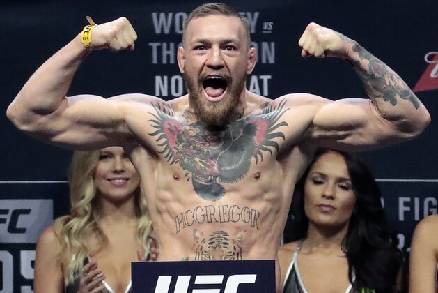 FILE - In this Nov. 11, 2016, file photo, Conor McGregor stands on a scale during the weigh-in event for his fight against Eddie Alvarez in UFC 205 mixed martial arts at Madison Square Garden in New York. Boxer Floyd Mayweather Jr. said Wednesday, June 14, 2017,  he will come out of retirement to face UFC star Conor McGregor in a boxing match on Aug. 26. Mayweather, who retired in September 2015 after winning all 49 of his pro fights, will face a mixed martial arts fighter who has never been in a scheduled 12-round fight at the MGM Grand arena. The fight will take place in a boxing ring and be governed by boxing rules. (AP Photo/Julio Cortez, File)