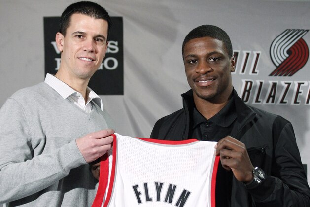 Portland Trail Blazers guard Jonny Flynn holds his new jersey with interim general manager Chad Buchanan, left, during a news conference introducing center Hasheem Thabeet and Flynn on Monday, March 19, 2012, in Portland, Ore. Thabeet and Flynn were acquired, along with a second-round draft pick, from Houston in exchange for veteran Marcus Camby last Thursday at the trade deadline. The Blazers also traded forward Gerald Wallace to the New Jersey Nets for center Mehmet Okur, forward Shawne Williams and a protected first-round pick. The two deals netted the Blazers cap space and added to a stockpile of picks for this June's NBA draft. (AP Photo/Rick Bowmer)
