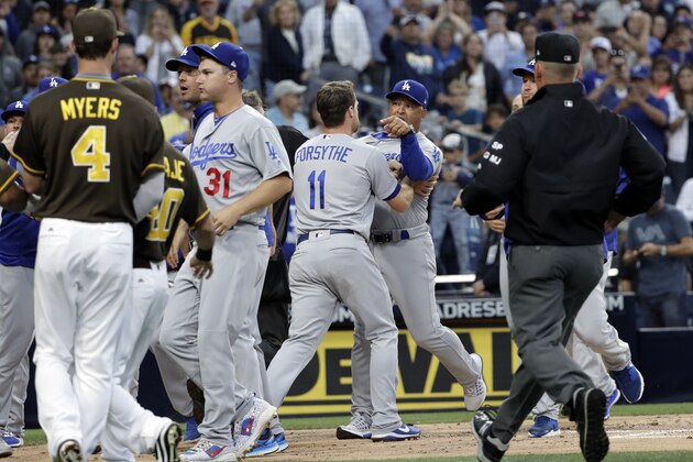Los Angeles Dodgers manager Dave Roberts, center rear, is held back by third baseman Logan Forsythe (11) as the Dodgers and the San Diego Padres come onto the field during an argument in the second inning of a baseball game Friday, June 30, 2017, in San Diego. (AP Photo/Gregory Bull)