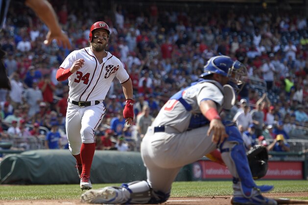 Washington Nationals' Bryce Harper runs towards home to score on a hit by Ryan Zimmerman AS Chicago Cubs catcher Willson Contreras, right, waits for the throw during the first inning of a baseball game, Thursday, June 29, 2017, in Washington. (AP Photo/Nick Wass)