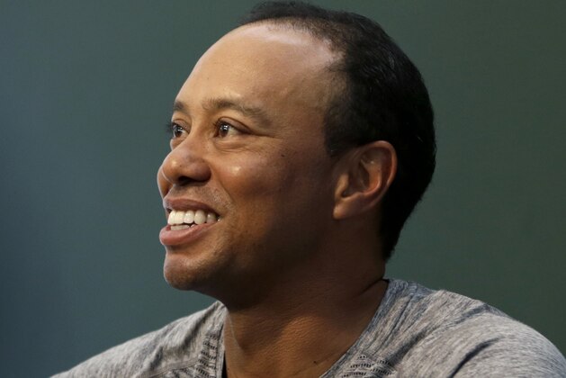 Golfer Tiger Woods signs copies of his new book in New York, Monday, March 20, 2017. (AP Photo/Seth Wenig)