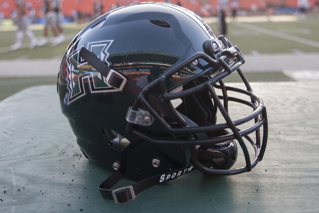 A Hawaii football helmet sits on a case before the start of an NCAA college football game, Saturday, Sept. 19, 2015, in Honolulu. (AP Photo/Eugene Tanner)