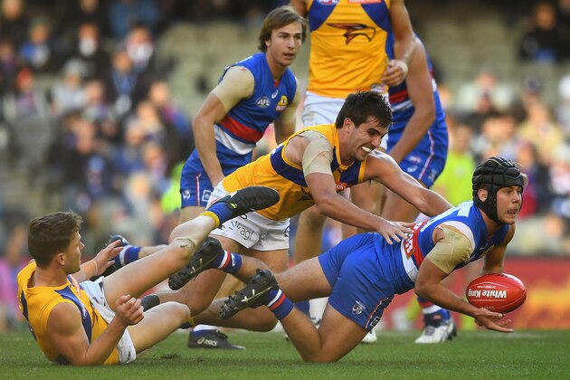 MELBOURNE, AUSTRALIA - JULY 01:  Caleb Daniel of the Bulldogs handballs whilst being tackled by Andrew Gaff of the Eagles during the round 15 AFL match between the Western Bulldogs and the West Coast Eagles at Etihad Stadium on July 1, 2017 in Melbourne, Australia.  (Photo by Quinn Rooney/Getty Images)