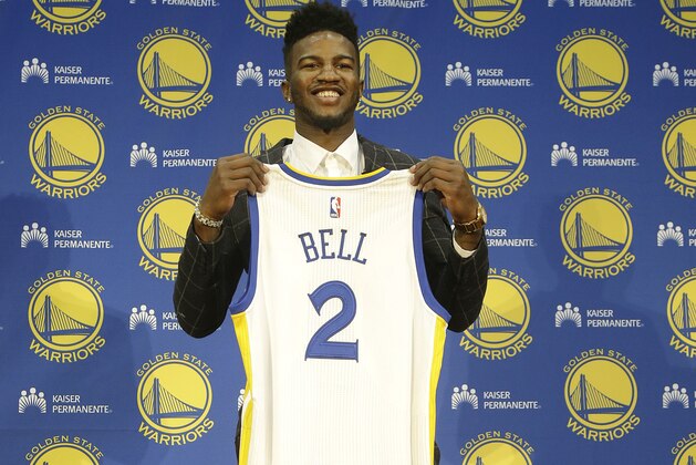 Golden State Warriors NBA basketball draft pick Jordan Bell poses for photos with a jersey at a news conference in Oakland, Calif., Friday, June 23, 2017. (AP Photo/Jeff Chiu)