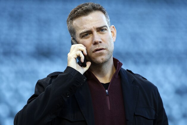 Chicago Cubs president for baseball operations Theo Epstein talks on his phone during a team workout in preparation for Saturday's Game 1 in baseball's National League Championship Series in Chicago, Thursday, Oct. 13, 2016. (AP Photo/Nam Y. Huh)