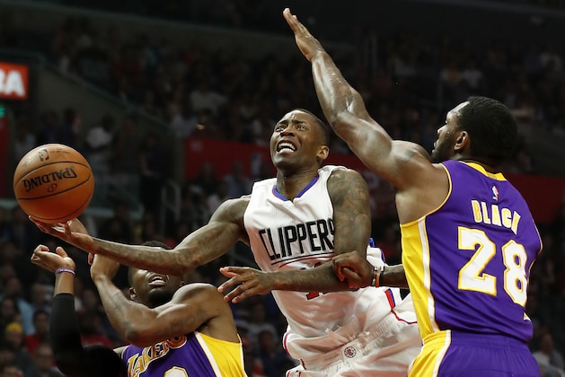 Los Angeles Clippers guard Jamal Crawford, center, goes to the basket in between Los Angeles Lakers guard David Nwaba, left, and center Tarik Black, right, during the first half of an NBA basketball game, Saturday, April 1, 2017, in Los Angeles. (AP Photo/Ryan Kang)
