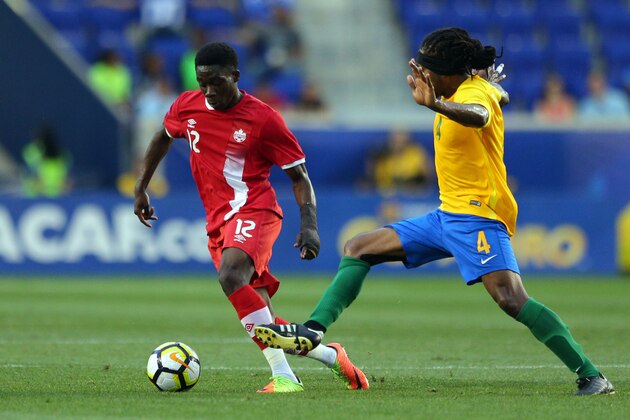 Jul 7, 2017; Harrison, NJ, USA; Canada midfielder Alphonso Davies (12) plays the ball against French Guiana forward Rhudy Evens (4) during the first half at Red Bull Arena. Mandatory Credit: Brad Penner-USA TODAY Sports