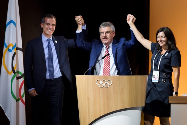 (LtoR) Mayor of Paris Anne Hidalgo, International Olympic Committee (IOC) President German Thomas Bach and Los Angeles Mayor Eric Garcetti reacts on the podium during an International Olympic Committee (IOC) extraordinary session on July 11, 2017 in Lausanne.
The International Olympic Committee on July 11 agreed to award the 2024 and 2028 Games at the same time, effectively guaranteeing that Paris and Los Angeles will be the hosts. The decision was made by consensus at a meeting of IOC members in Lausanne, Switzerland, after a strong lobbying effort by IOC boss who wanted both cities, which had been rivals for 2024, to get the Games. / AFP PHOTO / Fabrice COFFRINI        (Photo credit should read FABRICE COFFRINI/AFP/Getty Images)