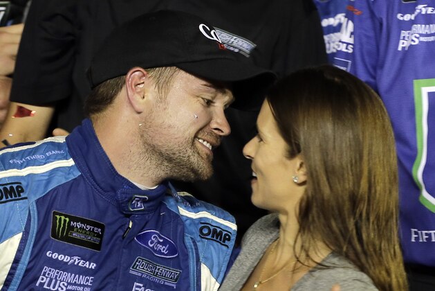 Ricky Stenhouse Jr., left, gets a kiss from girlfriend Danica Patrick in Victory Lane after he won the NASCAR Cup Series auto race at Daytona International Speedway, Saturday, July 1, 2017, in Daytona Beach, Fla. (AP Photo/Terry Renna)