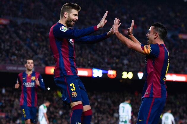 BARCELONA, SPAIN - DECEMBER 20:  Gerard Pique of FC Barcelona celebrates with his teammate Xavi Hernandez of FC Barcelona after scoring his team's third goal during the La Liga match between FC Barcelona and Cordoba CF at Camp Nou on December 20, 2014 in Barcelona, Spain.  (Photo by David Ramos/Getty Images)