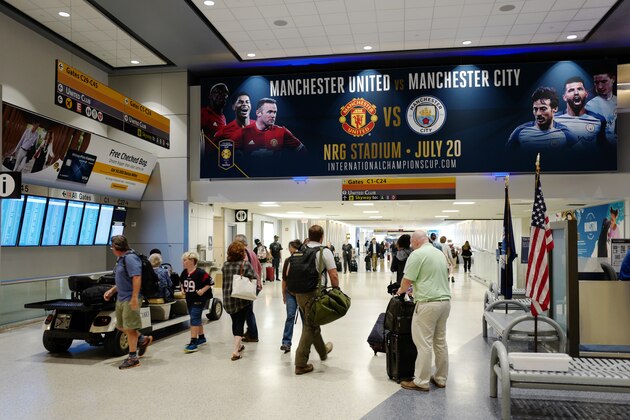HOUSTON, TX - JULY 11: Passengers walk through the terminal at the George Bush Intercontinental Airport with signage to promote the Manchester United v Manchester City - International Champions Cup 2017 fixture taking place a the NRG Stadium, on July 11, 2017 in Houston, Texas. (Photo by Matthew Ashton - AMA/Getty Images)