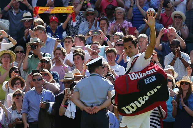 Switzerland's Roger Federer waves as he leaves the court after beating Croatia's Marin Cilic during their men's singles quarter-final match on the tenth day of the 2016 Wimbledon Championships at The All England Lawn Tennis Club in Wimbledon, southwest London, on July 6, 2016. / AFP / JUSTIN TALLIS / RESTRICTED TO EDITORIAL USE        (Photo credit should read JUSTIN TALLIS/AFP/Getty Images)