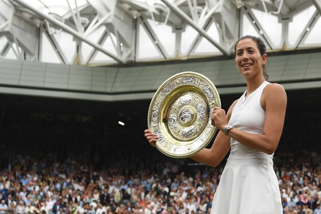 Spain's Garbine Muguruza holds up The Venus Rosewater Dish as she celebrates beating US player Venus Williams to win the women's singles final on the twelfth day of the 2017 Wimbledon Championships at The All England Lawn Tennis Club in Wimbledon, southwest London, on July 15, 2017. / AFP PHOTO / FACUNDO ARRIZABALAGA / RESTRICTED TO EDITORIAL USE        (Photo credit should read FACUNDO ARRIZABALAGA/AFP/Getty Images)