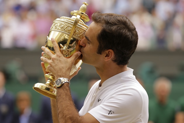 Switzerland's Roger Federer kisses the trophy after defeating Croatia's Marin Cilic to win the Men's Singles final match on day thirteen at the Wimbledon Tennis Championships in London Sunday, July 16, 2017. (AP Photo/Alastair Grant)