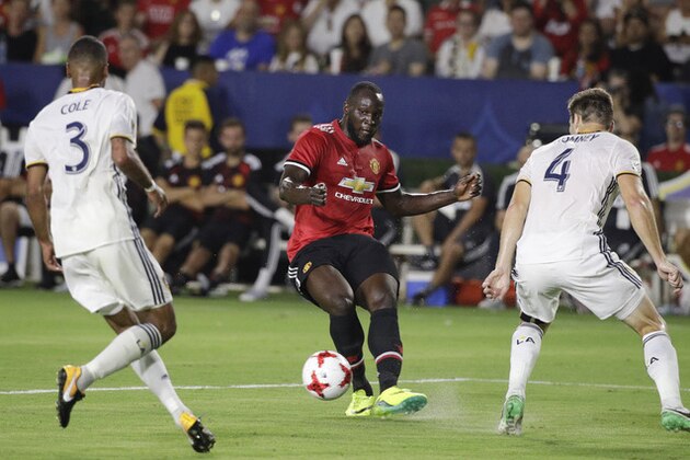 Manchester United's Romelo Lukaku, center, passes the ball under pressure by Los Angeles Galaxy's Dave Romney, right, and Ashley Cole during the second half of a friendly soccer match Saturday, July 15, 2017, in Carson, Calif. The Manchester United won 5-2. (AP Photo/Jae C. Hong)