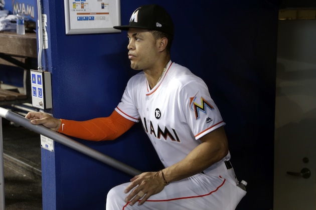 Miami Marlins right fielder Giancarlo Stanton watches from the dugout before a baseball game against the Philadelphia Phillies, Wednesday, May 31, 2017, in Miami. Stanton is not in the lineup due to mild hamstring cramping. (AP Photo/Lynne Sladky)