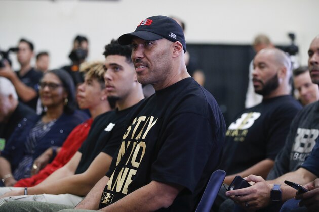 LaVar Ball, center, father of Los Angeles Lakers draft pick Lonzo Ball, listens to his son during the NBA basketball team's news conference, Friday, June 23, 2017, in El Segundo, Calif. (AP Photo/Jae C. Hong)