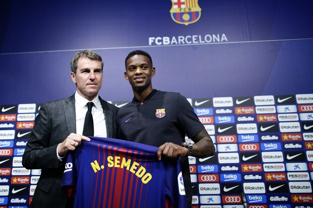 FC Barcelona's new signing Nelson Semedo, right, and FC Barcelona technical secretary Robert Fernandez hold a shirt during his official presentation at the Camp Nou stadium in Barcelona, Spain, Friday, July 14, 2017. (AP Photo/Manu Fernandez)