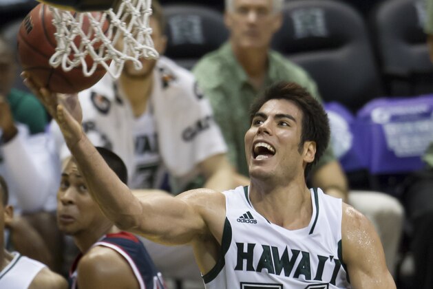 Hawaii forward Christian Standhardinger (34) shoots a layup as St. Mary's guard Stephen Holt, left, looks on in the second half of an NCAA college basketball game at the Diamond Head Classic Monday, Dec. 23, 2013, in Honolulu. Hawaii beat Saint Mary's 76-74. (AP Photo/Eugene Tanner)