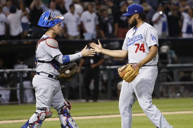 Los Angeles Dodgers relief pitcher Kenley Jansen (74) celebrates with catcher Yasmani Grandal after the team's 1-0 win over the Chicago White Sox in a baseball game Tuesday, July 18, 2017, in Chicago. (AP Photo/Charles Rex Arbogast)