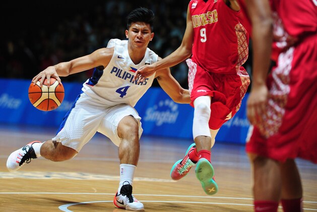 Sandy Febrianysah Kurniawan of Indonesia (R) attempts to block against Kiefer Ravena of the Philippines (L) during the men's basketball gold medal match at the 28th Southeast Asian Games (SEA Games) in Singapore on June 15, 2015. AFP PHOTO / MOHD FYROL        (Photo credit should read MOHD FYROL/AFP/Getty Images)