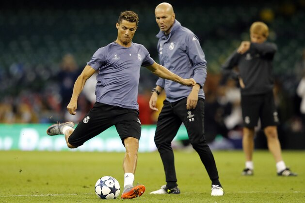 Real Madrid's Cristiano Ronaldo is watched by head coach Zinedine Zidane, right, during a training session at the Millennium Stadium in Cardiff, Wales Friday June 2, 2017. Real Madrid will play Juventus in the final of the Champions League soccer match in Cardiff on Saturday. (AP Photo/Frank Augstein)
