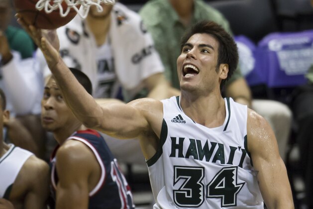 Hawaii forward Christian Standhardinger (34) shoots a layup as St. Mary's guard Stephen Holt, left, looks on in the second half of an NCAA college basketball game at the Diamond Head Classic Monday, Dec. 23, 2013, in Honolulu. Hawaii beat Saint Mary's 76-74. (AP Photo/Eugene Tanner)