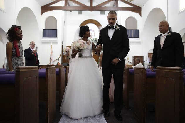 Two-time Olympic jumper Jamie Nieto, right, who was paralyzed from neck down 15 months ago after a spinal cord injury, walks down the aisle with his bride Shevon Stoddart after their wedding ceremony Saturday, July 22, 2017, in El Cajon, Calif. Step by halting step, Nieto made good on his vow to walk his new wife down the aisle of the church and out the door to a waiting limousine. It was roughly 130 steps, with a stop about halfway down the aisle for a kiss to appease the photographers. No cane, no walker, just his right arm holding onto his wife's left arm. (AP Photo/Jae C. Hong)