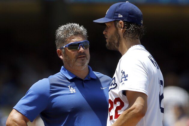 Los Angeles Dodgers starting pitcher Clayton Kershaw, right, talks with trainer Nathan Lucero during the second inning of a baseball game against the Atlanta Braves in Los Angeles, Sunday, July 23, 2017. Kershaw continued to pitch and completed the second inning, but did not return for the third inning. (AP Photo/Alex Gallardo)