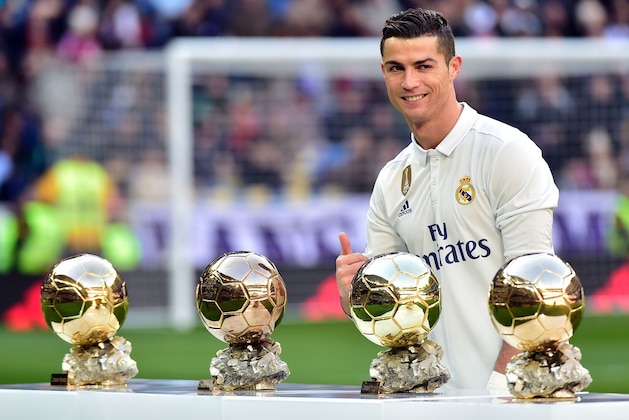 TOPSHOT - Real Madrid's Portuguese forward Cristiano Ronaldo poses with his four Ballon d'Or France Football trophies before the Spanish league football match Real Madrid CF vs Granada FC at the Santiago Bernabeu stadium in Madrid on January 7, 2017. / AFP / GERARD JULIEN        (Photo credit should read GERARD JULIEN/AFP/Getty Images)